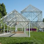 A large glass building with white metal structure.