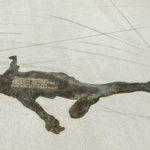 Concrete sidewalk with a faint image of a person etched into the cement.